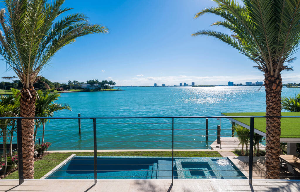 Miami Beach - April 2019: View of a nice pool and waterfront from terrace of a luxury home.