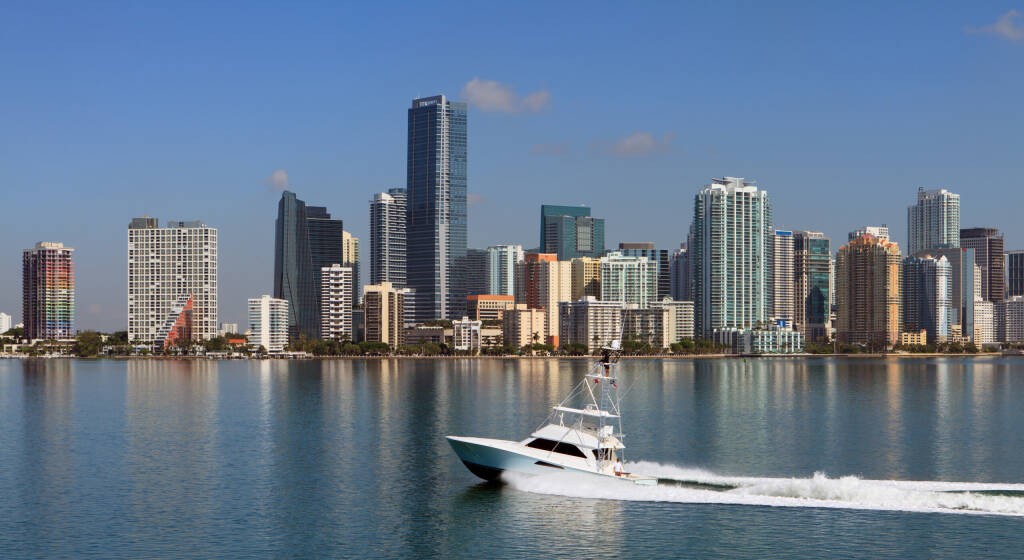 Panoramic Skyline view of Miami and Biscayne Bay from the Key Biscayne Bridge with fishing yacht cruising by.