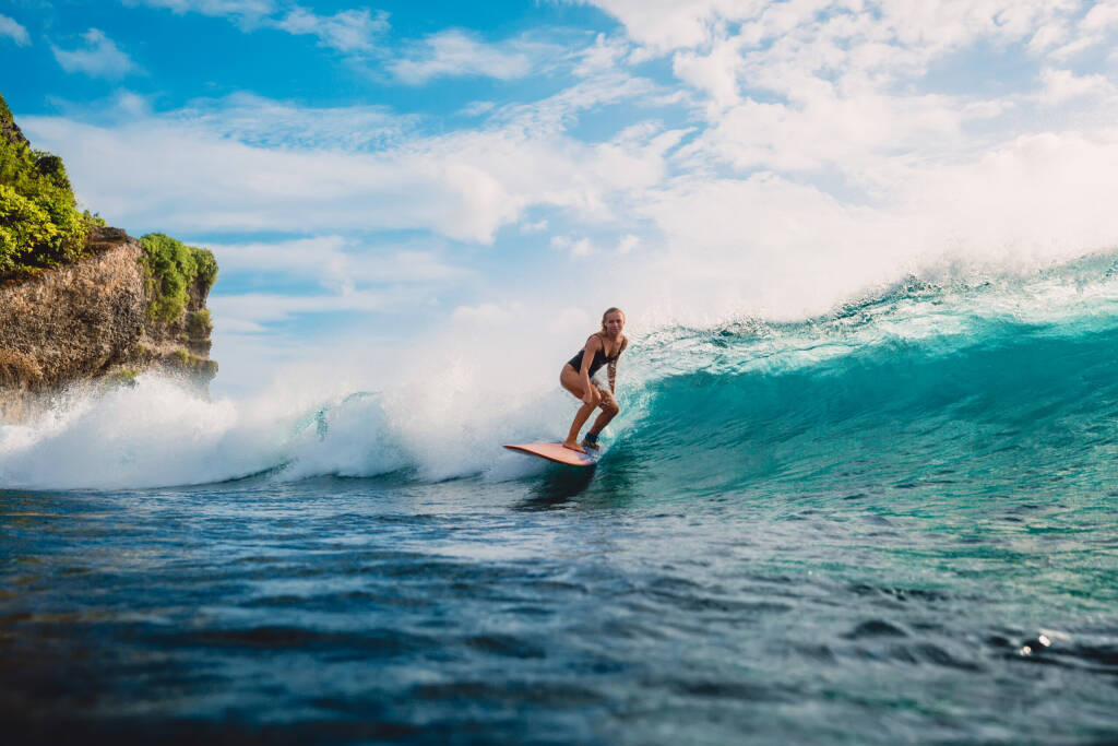 Surf dziewczyna na desce surfingowej. Kobieta w oceanie podczas surfingu.  