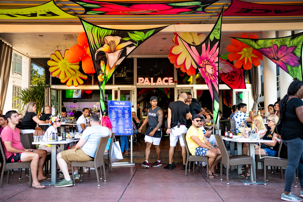 Miami Beach, USA — Ludzie siedzą i piją w barze The Palace w dzielnicy Art Deco w South Beach na Florydzie latem, licencjat: shutterstock/Autor: Andriy Blokhin