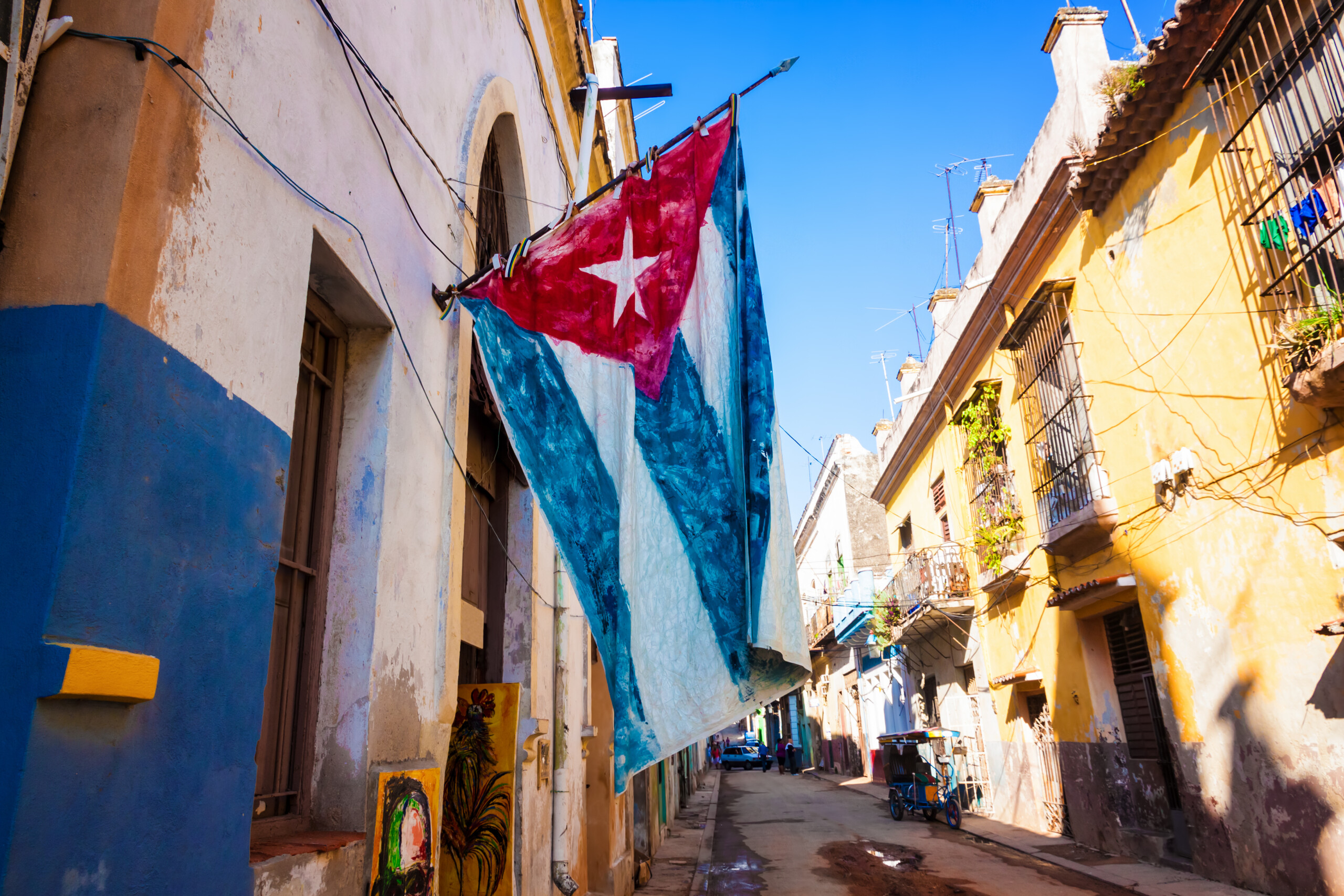 Ulica i budynki w Starej Hawanie z dużą kubańską flagą, licencja: shutterstock/By Kamira
