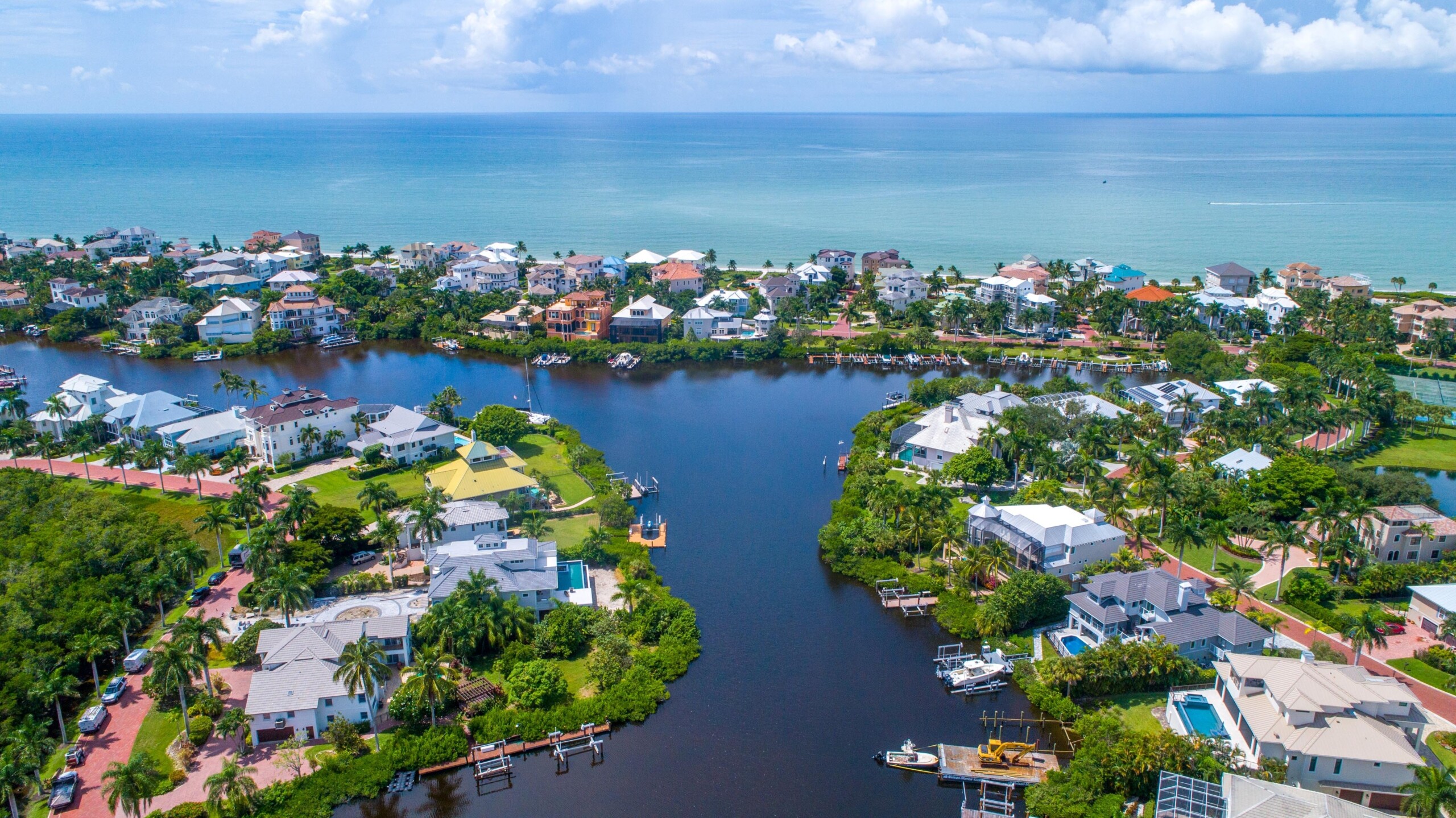 Widok z lotu ptaka z drona na domy z dokami na wodach Blue Bay otoczone lasami namorzynowymi w Bonita Springs na Florydzie i Zatokę Meksykańską w tle z czystym niebem, licencja: shutterstock/By RayDukin